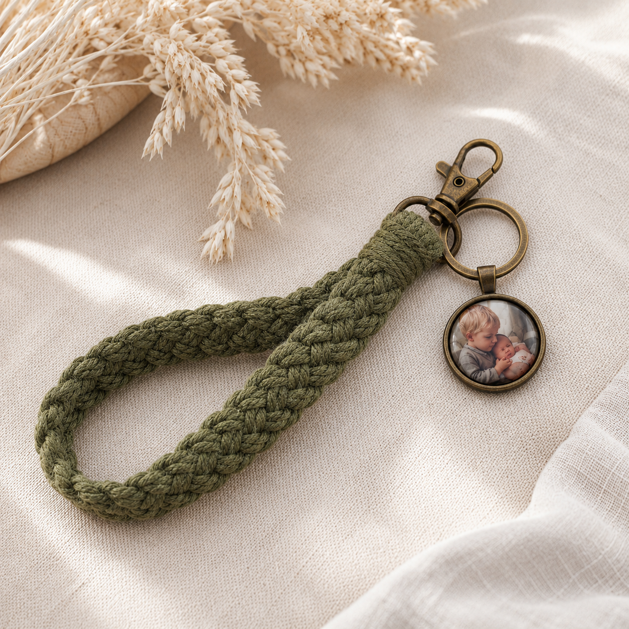 Khaki Makramee-Schlüsselanhänger mit rundem Foto-Anhänger und antikfarbenen Metallbeschlägen im Boho-Stil.