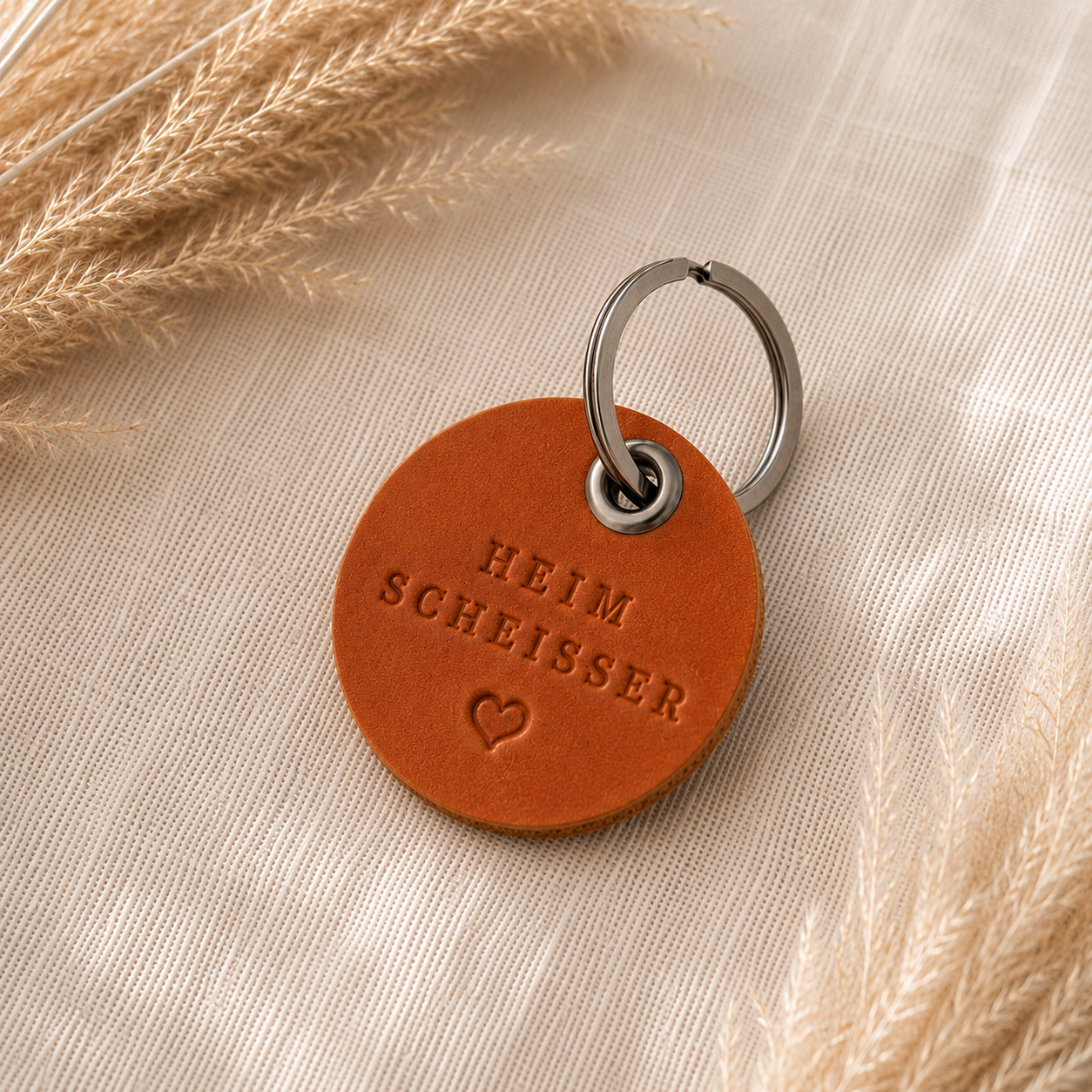 Handgefertigter Leder-Schlüsselanhänger in Braun mit individuellem Wunschtext und Metallring.
