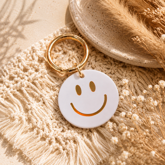 runder Smilie-schlüsselanhänger in pastellblau und goldfarbenem Ring. Perfekt als Geschenkidee.
