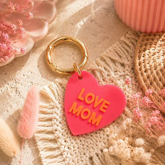 Pinker schlüsselanhänger in Herzform und mit LOVE MOM Schriftzug in Orange. Perfekt als Geschenkidee.