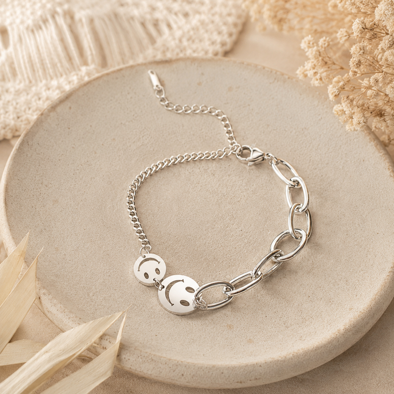 Silbernes Smiley-Armband aus Edelstahl auf hellem Boho-Hintergrund.